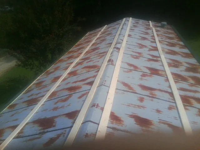 Rusted metal roof panels with new wood purlins before replacement — Storm Damage Roof Repair in Troutman by Roofing Brothers