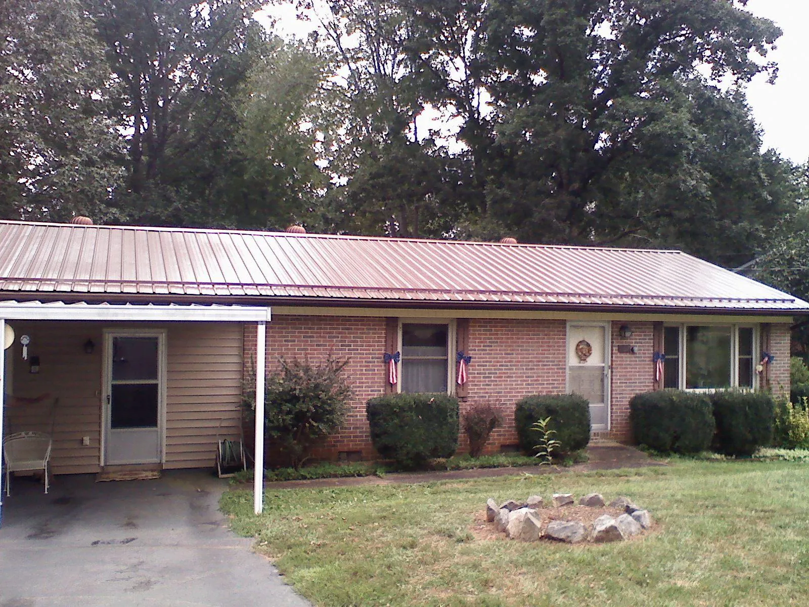 Bronze metal roof and carport on a brick ranch home — Roof Repair work by our crew in Troutman