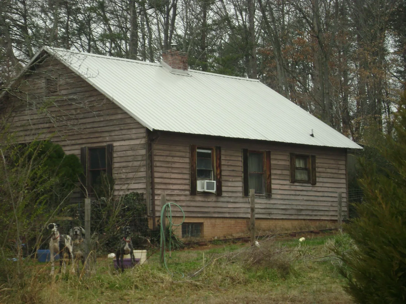White metal roof on an old wood sided farmhouse, from a Metal Roof Installation job in Troutman